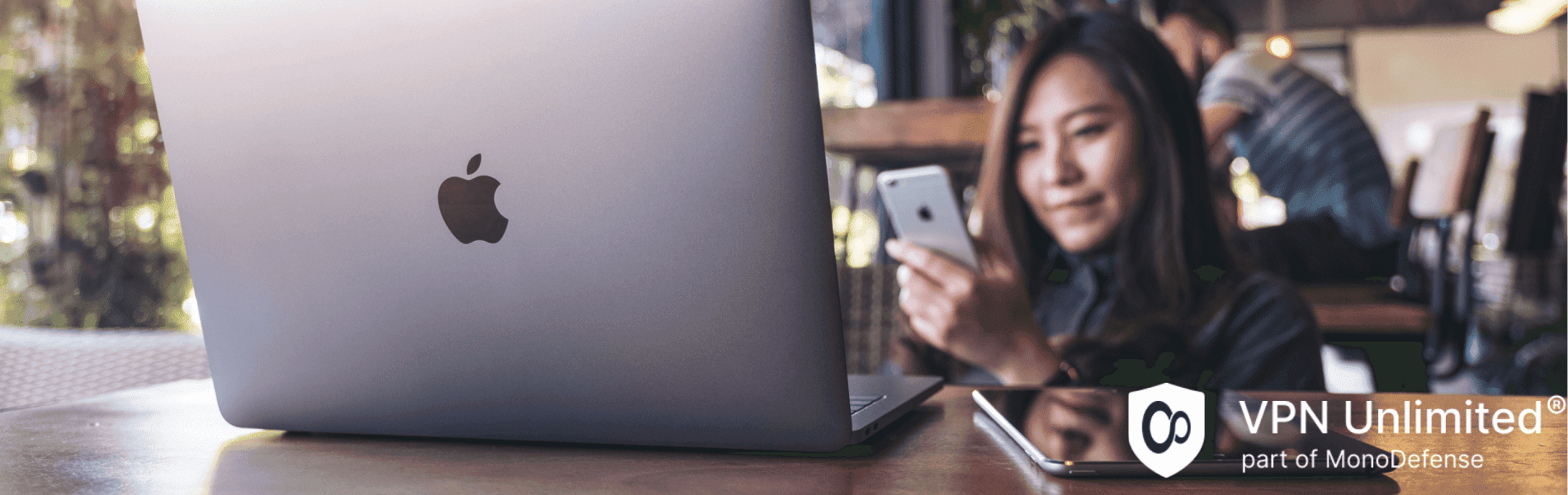 A woman sitting in a cafe with her Mac, with VPN set up on Mac
