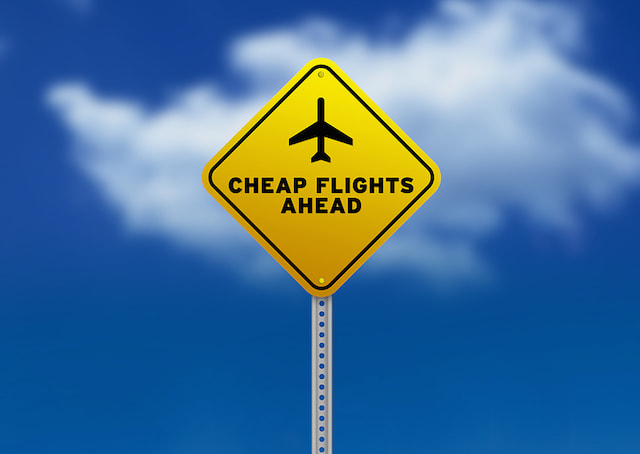 bigstock-cheap-flights-ahead-road-sign-20797673