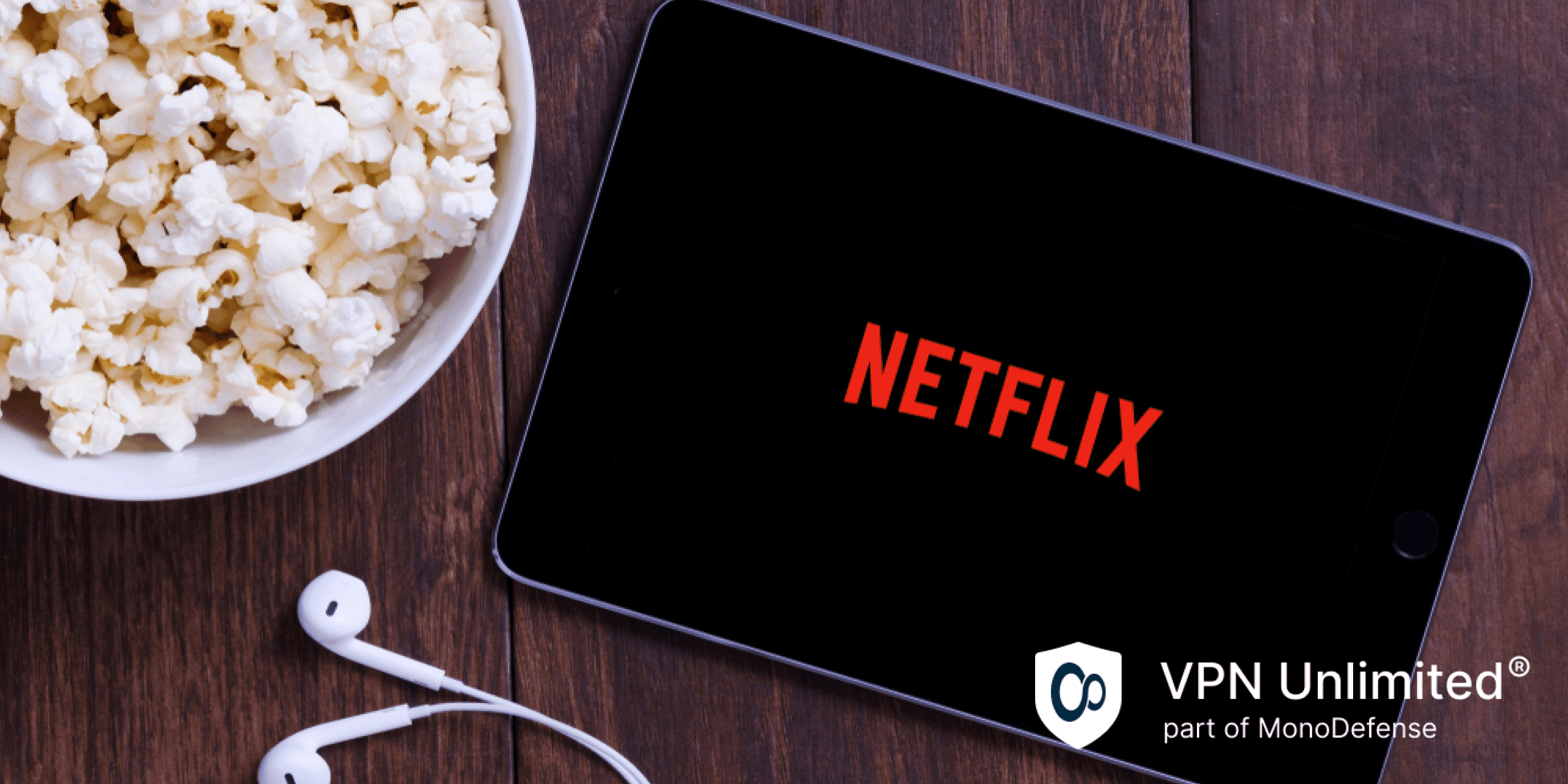 Table with popcorn bottle and Netflix logo on Apple Ipad mini and earphone, streaming Netflix with VPN Unlimited
