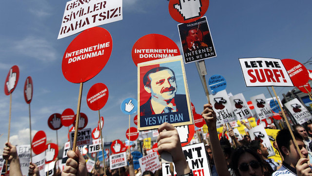 Demonstrators hold placards with some featuring a picture of Turkey's PM Erdogan during a protest against internet censorship in Istanbul